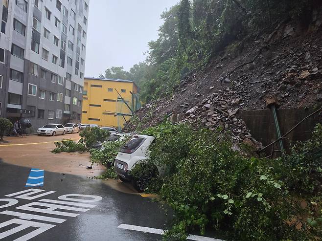 17일 산사태가 난 경남 거제시 옥포동 한 아파트 단지 주차장에 야산에서 쓸려 내려온 토사와 나무가 뒤엉켜 있다. 경남소방본부 제공