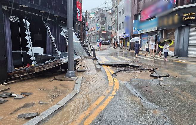 17일 오전 경남 거제시 옥포동 한 상가 일대에서 집중호우로 점포 유리창이 깨지고 도로 아스팔트가 뜯겨 나가는 등 피해가 발생했다. 연합뉴스