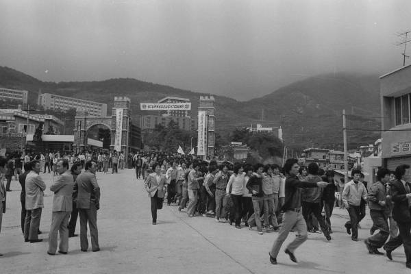 1979년 부마항쟁 이듬해 봄, 경남대학교 학생들이 비상계엄령에 반대하며 교문 밖 월영광장으로 나오고 있다. /경남대학교