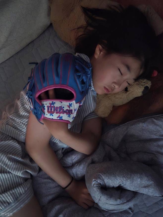 최서윤이 지난달 4일 광주 자택에서 박주아 선수에게 선물 받은 글러브를 낀 채 잠들어 있다. 최서윤 제공