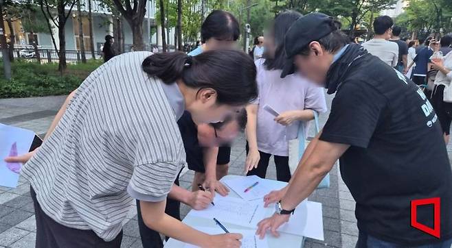 19일 오후 6시30분께 서울 용산구 용산어린이정원 정문 앞 한마음공원에서 시민들이 용산공원 부지 내 주택공급 반대를 위한 서명을 하고 있다. 심성아 기자