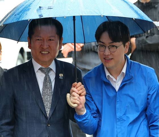 지난 5월 3일 오후 부산 북구 구포시장에서 정청래 더불어민주당 대표와 북갑 국회의원 보궐선거 출마를 공식화한 하정우 전 청와대 AI 미래기획수석이 우산을 쓰고 이동하고 있는 모습. 〈사진=연합뉴스〉