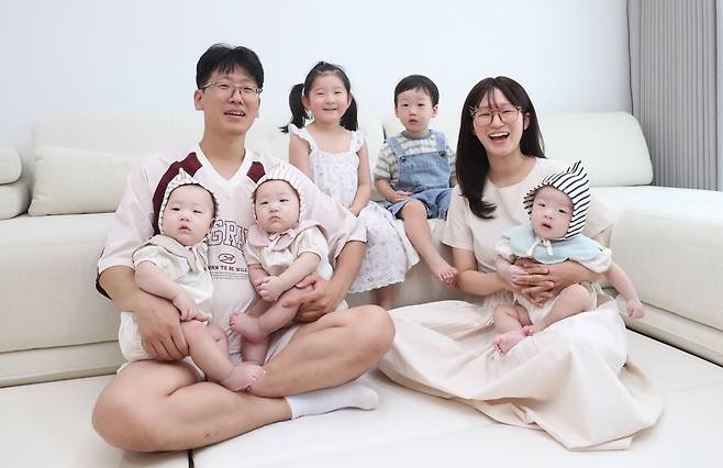 지난 6일 대구 동구 봉무동 채희진·최건호씨 부부의 집 거실에 온 가족이 다 함께 모여 환하게 웃고 있다. 왼쪽 위쪽부터 시계 방향으로 아빠 최씨, 첫째 담희, 둘째 도하, 엄마 채씨, 삼둥이 중 첫째 이도와 둘째 이현, 삼둥이 중 막내 이준. /대구=김동환 기자