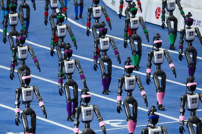 22일 베이징에서 열린 월드 휴머노이드 로봇 게임 2026 개막식에서 휴머노이드 로봇들이 퍼레이드를 펼치고 있다. EPA=연합뉴스