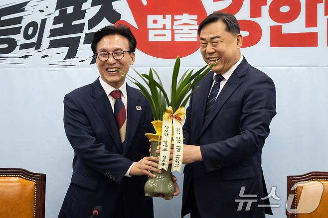 김종훈 진보당 대표가 24일 서울 여의도 국회에서 김민석 더불어민주당 대표를 접견, 당대표 취임 축하난을 선물하고 있다. 2026.8.24 ⓒ 뉴스1 유승관 기자