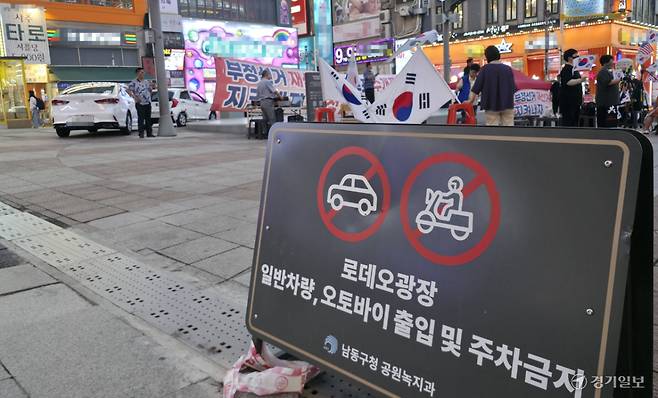 23일 오후 남동구 구월동 로데오광장 입구에 일반차량과 오토바이 출입을 금지한다는 팻말이 있지만, 집회 뒤로 관계자들의 차량이 버젓이 주차중이다. 장민재기자