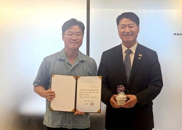 나영석 PD가 함명준(오른쪽) 고성군수로부터 홍보대사 위촉장을 받은뒤 포즈를 취하고 있다.