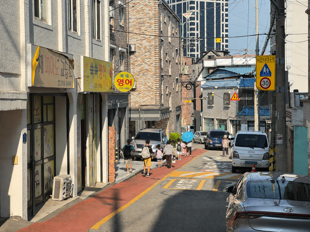 26일 오전 전주시 덕진구 금암초등학교 인근 어린이보호구역에서 학생들이 별도의 보도가 마련되지 않은 도로 가장자리를 따라 등교하고 있다. /이상구 기자