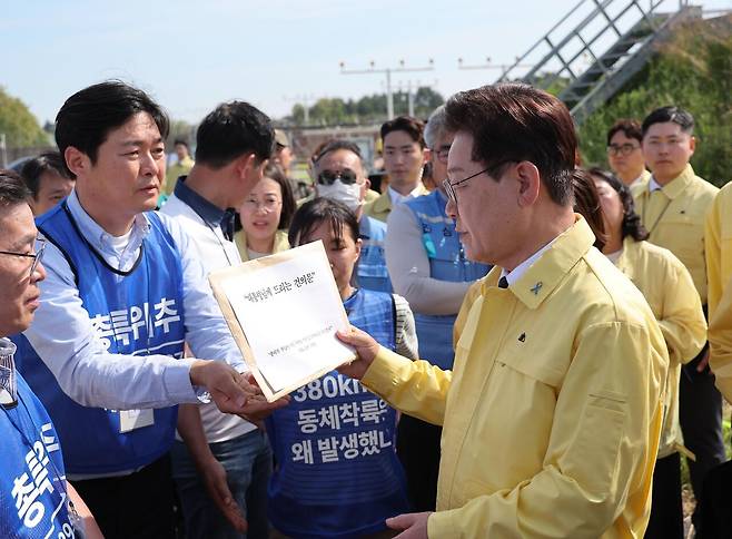 5월18일 이재명 대통령이 무안국제공항 유해 수습 현장에서 유가족으로부터 건의문을 받고 있다. ⓒ청와대통신사진기자단