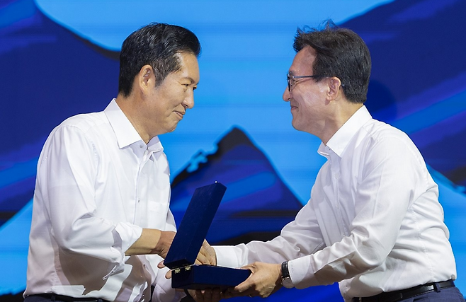 더불어민주당의 김민석 대표(오른쪽)가 8월27일 인천 중구 인스파이어 리조트에서 열린 2026년 정기국회 대비 국회의원 워크숍에서 전임 당 대표였던 정청래 의원에게 감사패를 전달하고 있다. ⓒ연합뉴스