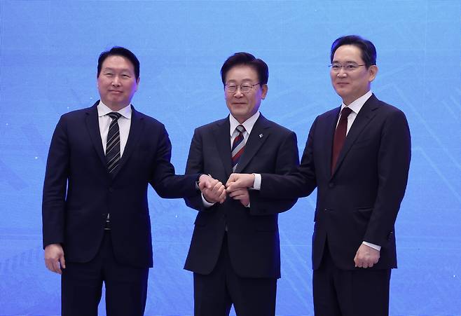이재명 대통령과 이재용 삼성전자 회장, 최태원 에스케이(SK)그룹 회장이 6월 29일 청와대에서 열린 ‘대한민국 대도약 3대 메가프로젝트 국민보고회’에서 손을 맞잡고 있다. 권욱 기자