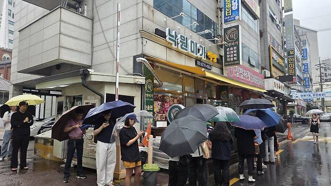 '피자떡'을 판매하는 동네떡집 앞에는 대기줄이 길게 늘어섰다. / 사진 = 조건희 기자.
