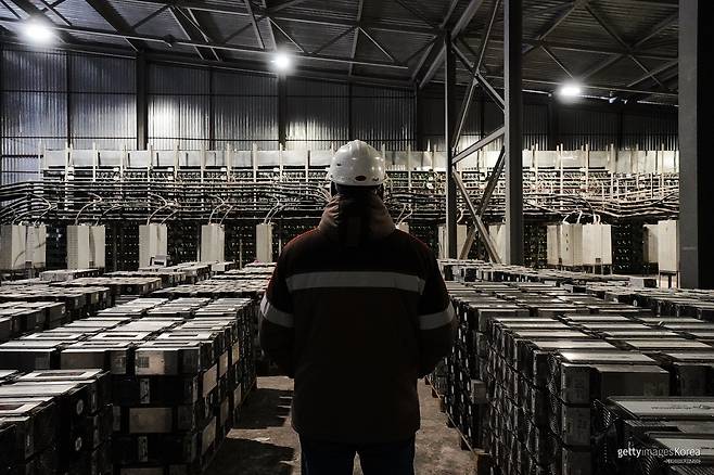카자흐스탄 에키바스투즈에 있는 대형 비트코인 채굴 데이터센터에서 직원이 채굴 설비를 점검하고 있다. 비트코인 채굴 수익성이 낮아지면서 전력 단가와 장비 효율에 따라 채굴을 유지하거나 AI·고성능컴퓨팅(HPC) 데이터센터로 전환하려는 움직임이 나타나고 있다. 2023년 1월 촬영. 게티이미지코리아