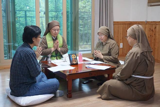 사제를 상징하는 영대를 두른 유용숙 프란시스 수녀사제(왼쪽에서 두 번째)가 작은 상에 둘러앉아 방문객과 함께 예식을 이끌고 있다. 성공회 프란시스 수녀회 제공