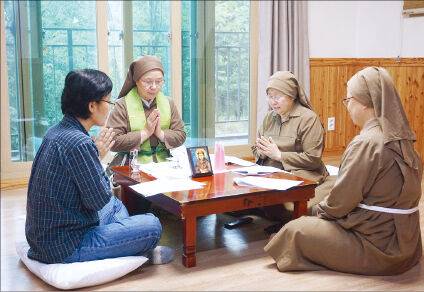 프란시스 수녀사제(왼쪽 두 번째)가 경북 구미 한옥 수도원에서 작은 상에 둘러앉아 방문객과 함께 기도하는 모습. 성공회 프란시스수녀회 제공