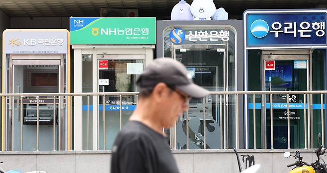 지난달 30일 주요 시중은행 ATM이 설치된 서울의 한 거리를 시민이 걷고 있다./연합뉴스