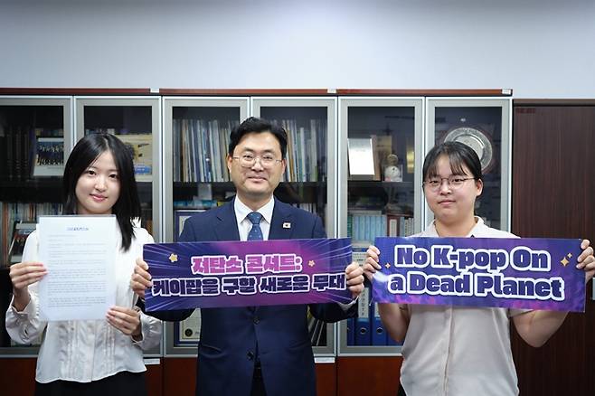 케이팝포플래닛은 지난 8일 서울 여의도 국회의원회관 제6간담회실에서 '탄소중립 공연 행사 가이드라인 제정을 위한 협의체' 출범식과 정책토론회를 열었다. 국회 문체위 간사를 맡은 더불어민주당 이정문 의원(가운데)이 케이팝포플래닛 활동가와 함께 슬로건을 든 모습. 케이팝포플래닛 제공