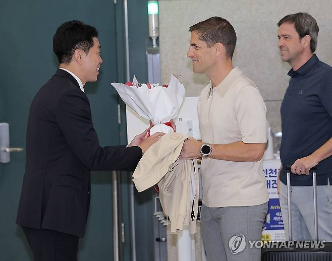 입국한 축구 대표팀 모레노 임시 감독 (영종도=연합뉴스) 류영석 기자 = 축구 국가대표팀 '임시 사령탑'으로 선임된 로베르트 모레노 감독이 13일 인천국제공항 제1여객터미널을 통해 입국해 현영민 대한축구협회 전력강화위원장으로부터 꽃다발을 받고 있다. 2026.9.13 ondol@yna.co.kr