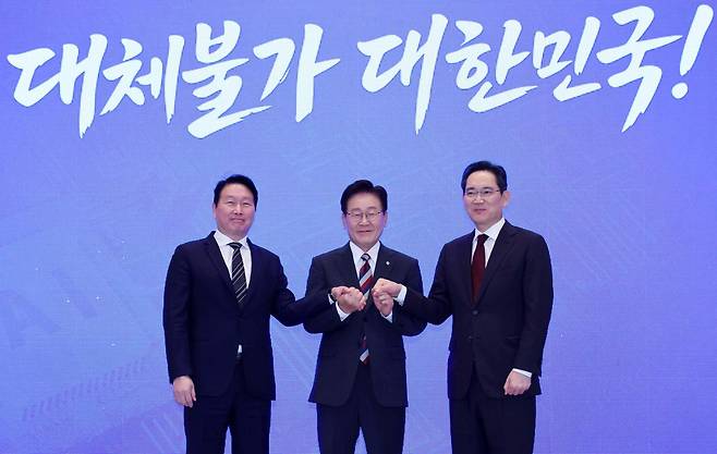 이재명(가운데) 대통령이 6월 청와대에서 열린 ‘대한민국 대도약 3대 메가프로젝트 국민보고회’에서 최태원(맨 왼쪽) SK그룹 회장과 이재용 삼성전자 회장과 함께 손을 맞잡고 있다. 왕태석 선임기자