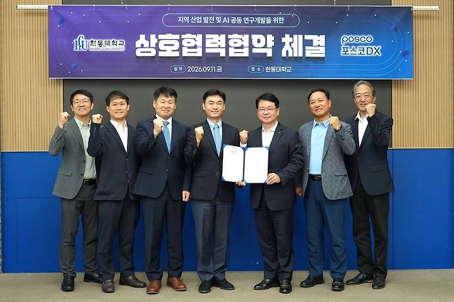 안민규 한동대 AI컴퓨터전자공학부 학부장, 이권영 산학협력단장, 김재효 기획처장, 박성진 총장, 심민석 포스코DX 대표이사, 조석주 AX융합연구소장, 조성원 기술전략그룹장(왼쪽부터)이 9월 11일 체결한 협약서를 들어 보이고 있다.