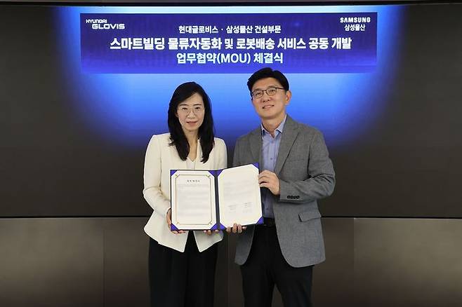 조혜정 삼성물산 DxP본부장(왼쪽)과 한규헌 현대글로비스 미래혁신기술센터장이 16일 현대글로비스 본사에서 ‘스마트빌딩 물류자동화 및 로봇배송 서비스 공동 개발업무협약’을 맺고 기념 촬영을 하고 있다. ⓒ현대글로비스