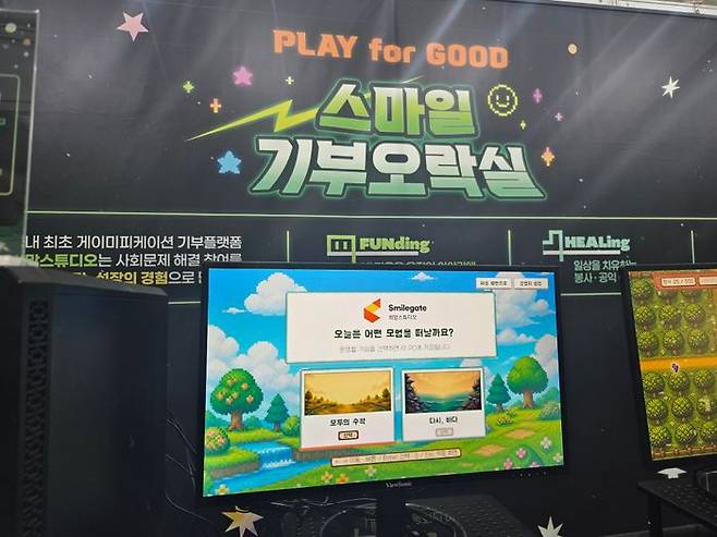 스마일게이트 희망스튜디오 '스마일 기부오락실'에 설치된 기부 게임 '모두의 수확'과 '다시, 바다' 선택 화면. ⓒ데일리안 정진주 기자