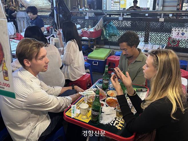 외국인 관광객들이 21일 서울 종로구 돈화문로11길에 위치한 거리가게에서 음식과 술을 주문하고 대화를 나누고 있다. 임주영 기자