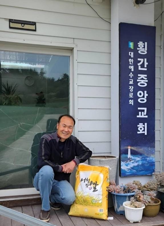 섬 목회자가 최근 전남 완도 횡간중앙교회 앞에서 낙도선교회가 보낸 쌀을 받고 기념사진을 찍고 있다. 낙도선교회 제공