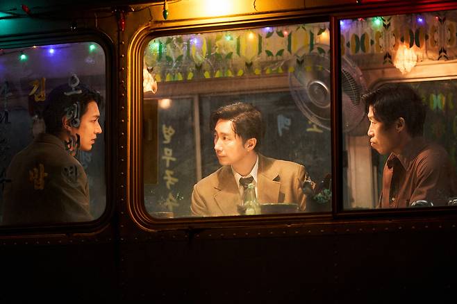 영화 <암살자(들)>의 기자 재환(박해일)과 영일(이민호), 경찰 철구(유해진)가 술집에 모여 앉아 이야기를 나누고 있다. 하이브미디어코프 제공