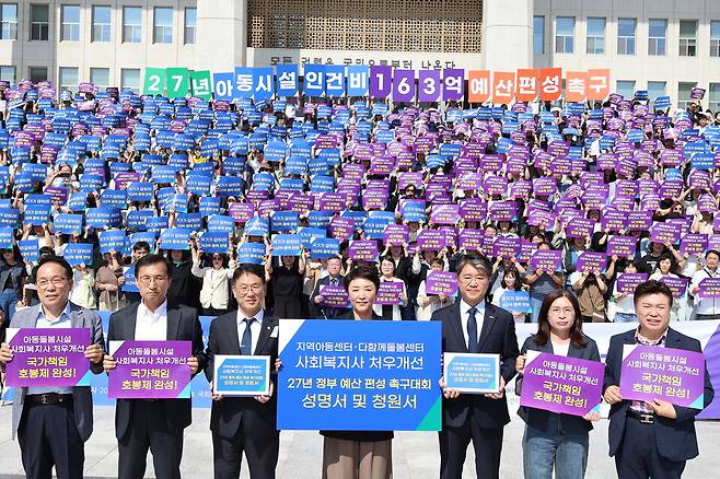 29일 지역아동센터총연대·전국다함께돌봄센터협회·한국사회복지사협회는 서울 여의도 국회 본관 앞에서 '지역아동센터·다함께돌봄센터 사회복지사 처우개선 2027년 정부 예산 편성 촉구대회'를 열고 인건비 가이드라인 100% 준수에 필요한 163억3000만원을 국회 심의 과정에서 추가 편성할 것을 촉구했다. /한국사회복지사협회