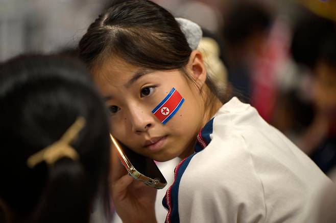 얼굴에 인공기 스티커를 붙인 재일본조선인총연합회(조총련) 응원단의 한 어린이가 28일 일본 나고야시 중소기업진흥회관에서 열린 2026 아이치·나고야 아시안게임 역도 남자 85㎏급 경기장 관중석에 앉아 있다. 나고야=하상윤 기자