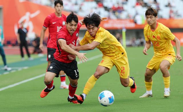 한국의 이현주가 30일 일본 오사카 나가이 스타디움에서 열린 2026 아이치·나고야 아시안게임 남자 축구 준결승 도중 먼저 공을 확보하기 위해 중국의 후허타오와 몸싸움을 벌이고 있다. 연합뉴스