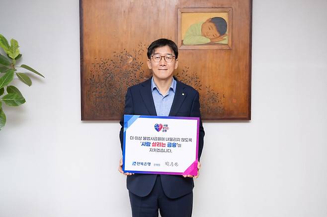  박춘원 전북은행장이 '사람 살리는 금융 릴레이 캠페인'에 동참하는 푯말을 들어보이고 있다. ⓒ전북은행 제공