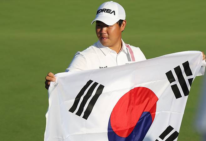 김주형이 3일 일본 아이치현 가스가이 컨트리클럽 동코스에서 열린 2026 아이치·나고야 아시안게임 남자 골프 4라운드를 마친 뒤 태극기를 들고 기념촬영을 하고 있다. 연합뉴스