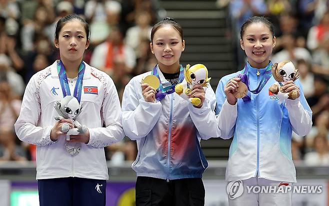 시상대 나란히 선 한국·북한·중국 (나고야=연합뉴스) 이동해 기자 = 24일 일본 나고야 종합체육관 레인보우홀에서 열린 2026 아이치·나고야 아시안게임 기계 체조 여자 도마에서 금메달을 차지한 여서정이 메달리스트들과 기념 촬영하고 있다. 왼쪽은 은메달리스트 북한 안창옥, 오른쪽은 동메달리스트 중국 두쓰위. 2026.9.24 eastsea@yna.co.kr