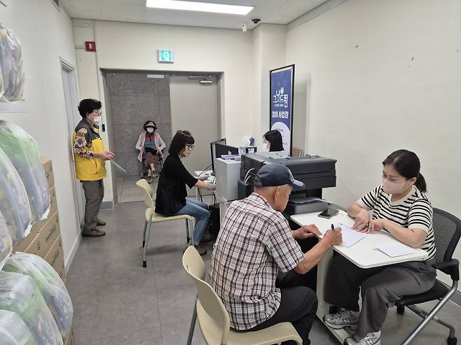 상주시종합사회복지관에서 '그냥드림' 이용 어르신이 신청서 작성과 복지 상담을 받고 있다. 이용자는 번호표 순서에 따라 입장해 신원 확인과 신청서 작성, 복지 상담을 거친 뒤 필요한 먹거리와 생필품을 지원받는다. (상주시종합사회복지관 제공)