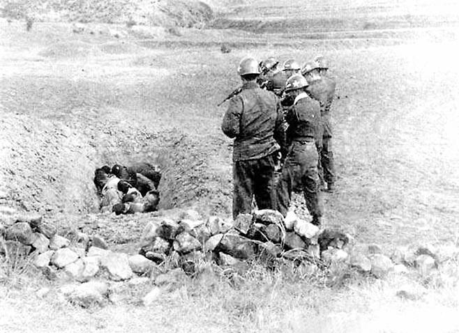 1951년 4월쯤 대구 인근 지역에서 군인들이 민간인들을 구덩이에 넣고 총을 겨누고 있다. 미국 국립문서기록관리청