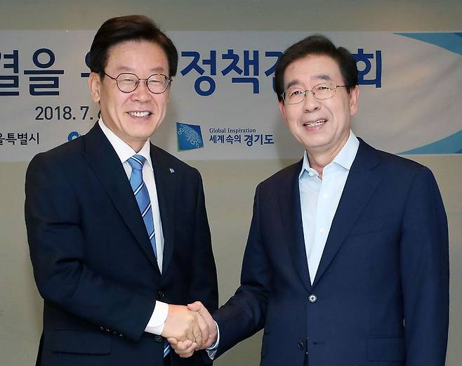당시 박원순 서울시장(오른쪽)과 이재명 경기지사가 지난 2018년 7월 6일 오전 서울 중구 한식당 달개비에서 열린 미세먼지 해결을 위한 환경부-수도권광역단체장 정책간담회에서 악수를 하고 있다. 뉴스1