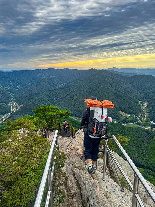 겹겹이 포개진 산줄기 위로 노란 여명이 길게 드리워진 천주산의 아침은 어둠속에서 거친 숨을 몰아치며 올라섰던 밤풍경과 대비된다.
