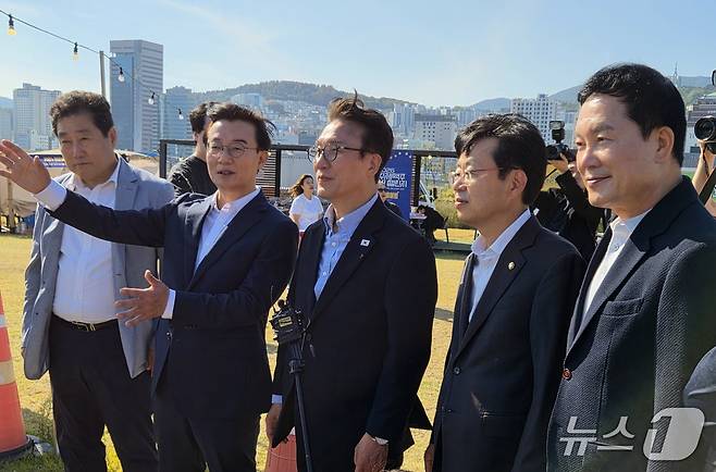 김민석 더불어민주당 당대표(사진 가운데)가 17일 오후 부산 동구 북항 돔 아레나 조성 예정 부지를 방문해 전재수 부산시장(왼쪽 두 번째)과 관계자들로부터 개발 계획에 대한 설명을 듣고 있다. 2026.10.17뉴스1 ⓒ News1 임순택 기자