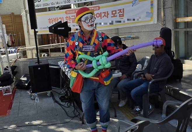 삐에로빈이 기타를 메고 노래하는 가수 옆에 서서 풍선 기타를 연주하는 시늉을 하고 있다. 그는 이날 분위기를 띄우는 역할을 자처했다. 백재연 기자