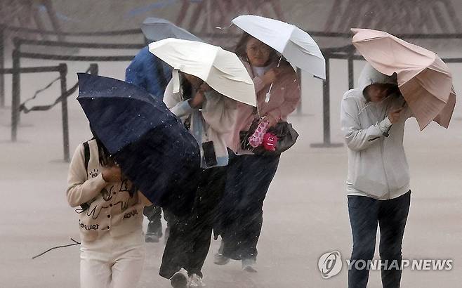 강풍 동반한 요란한 가을비 (서울=연합뉴스) 한종찬 기자 = 강풍을 동반한 강한 비가 내린 18일 서울 종로구 경복궁을 찾은 관람객들이 비를 피하고 있다. 2026.10.18 saba@yna.co.kr