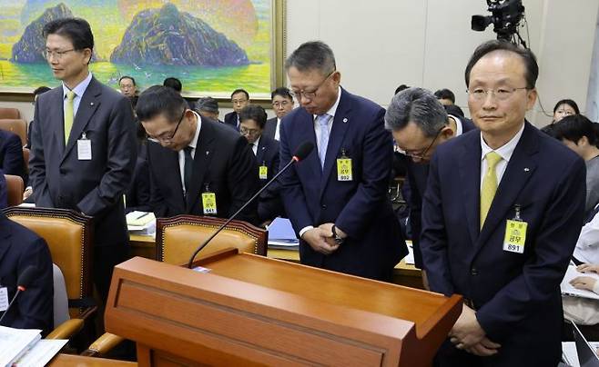 이환주 KB국민은행장(왼쪽)을 비롯한 시중은행장들이 19일 국회 정무위원회의 금융감독원 등에 대한 국정감사에서 국민의힘 박성훈 의원의 질의에 답하지 못한 채 두 손을 모으고 자리로 이동하고 있다. 왼쪽부터 강태영 NH농협은행장, 이호성 하나은행장, 정진완 우리은행장, 정상혁 신한은행장, 이환주 KB국민은행장. 연합뉴스