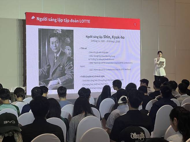 지난 21일 베트남 수도 하노이 시내에서 30여㎞ 떨어진 호아락 파크 내 FPT대학교 대강당에서 개최된 '2026 롯데 글로벌 캠퍼스 리크루팅 인 베트남' 행사에서 롯대백화점 관계자가 학생들에게 롯데 창업주 신격호 회장에 대해 설명하고 있다. 사진=김준석 특파원